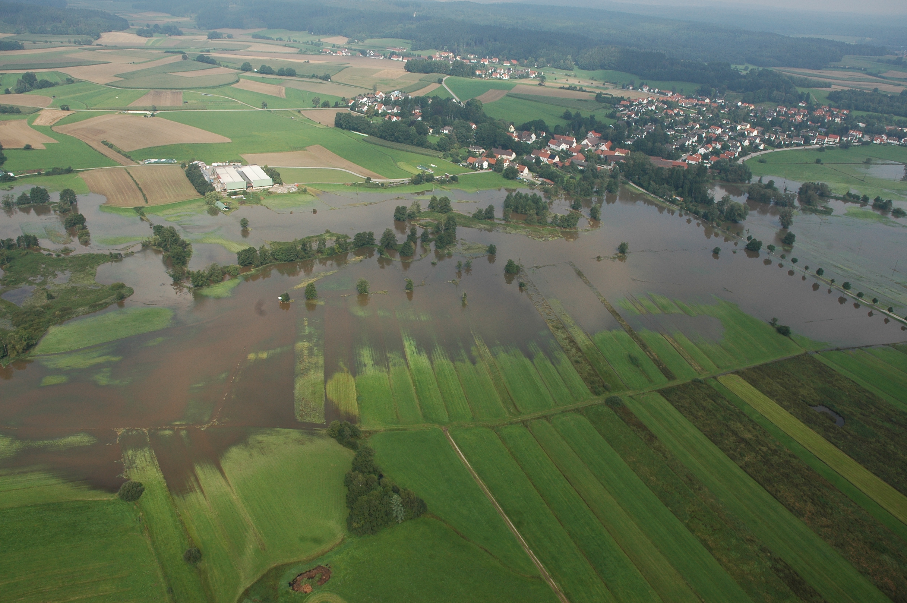 Auf dem Foto sind die weitflächigen ÜBerflutungsflächen der Schmutter bei Gessertshausen im Hochwasser 2005 zu sehen.